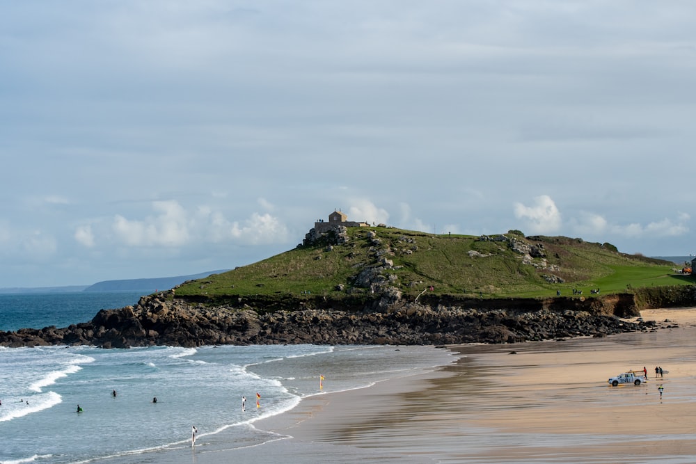 people at the shore near the hill