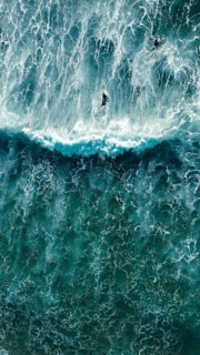 two surfers riding a large wave in the ocean