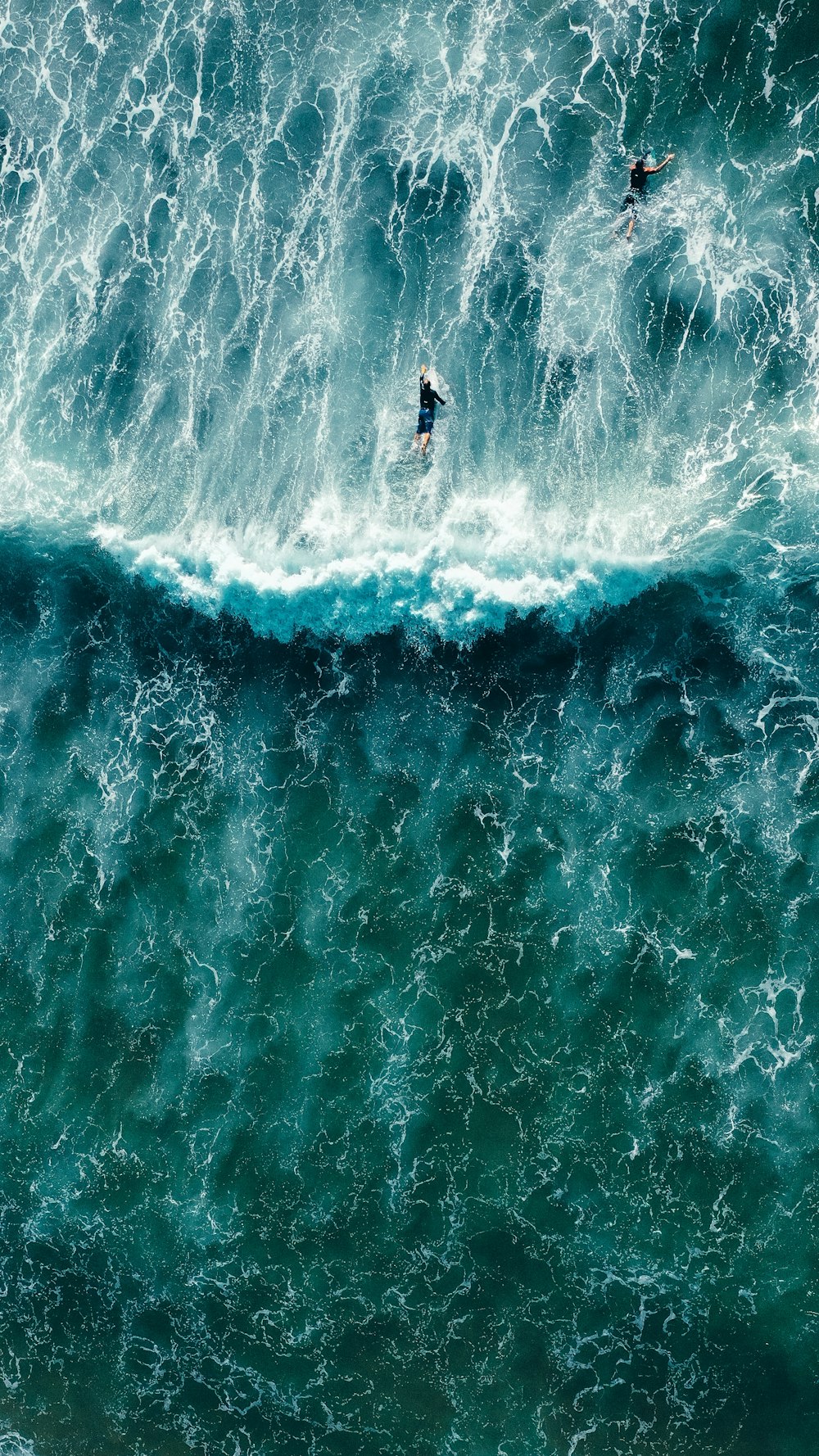 two surfers riding a large wave in the ocean