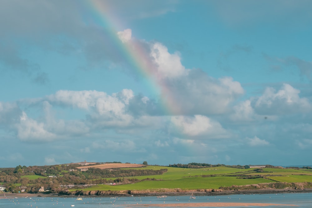 rainbow above green plain field