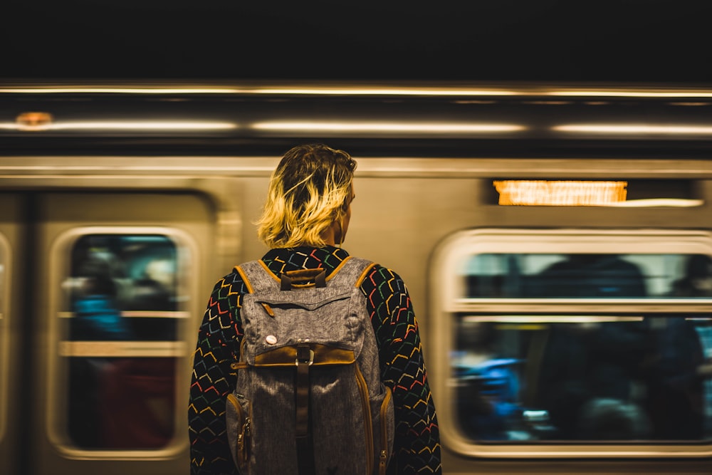 man standing near moving train