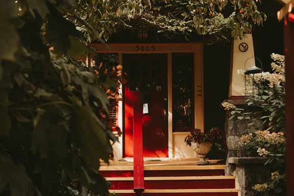 A welcoming home entrance with a bright door and cozy outdoor seating.