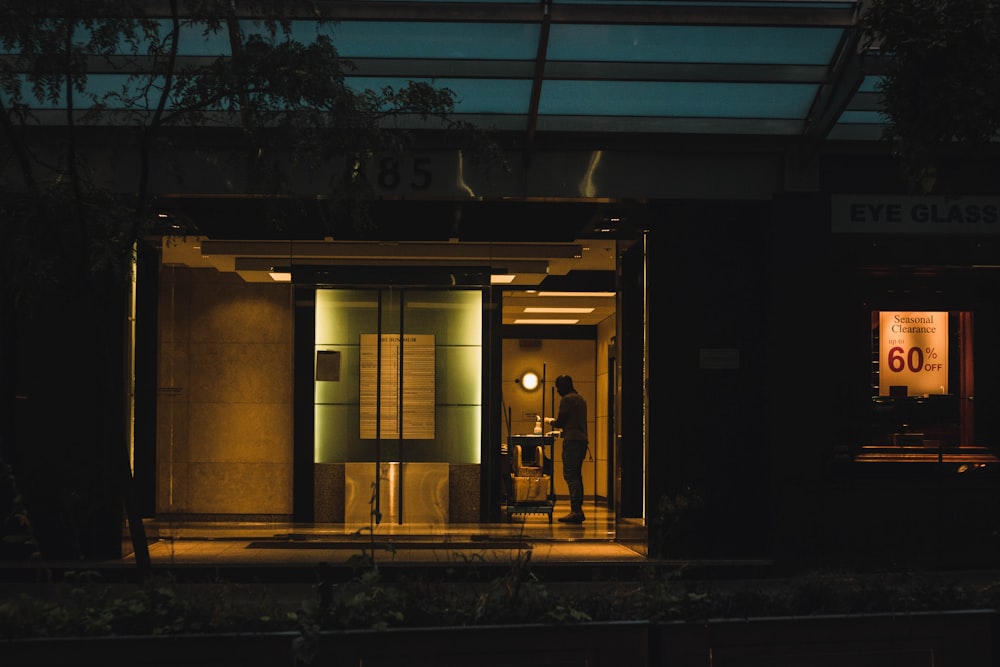 a man standing outside of a building at night