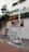 A street scene depicting a corner of a building with signage for 'Mogambo Singapore' and 'Canton St' visible. The exterior features street lamps and a no entry sign in the foreground. A billboard advertises food with images of dishes.