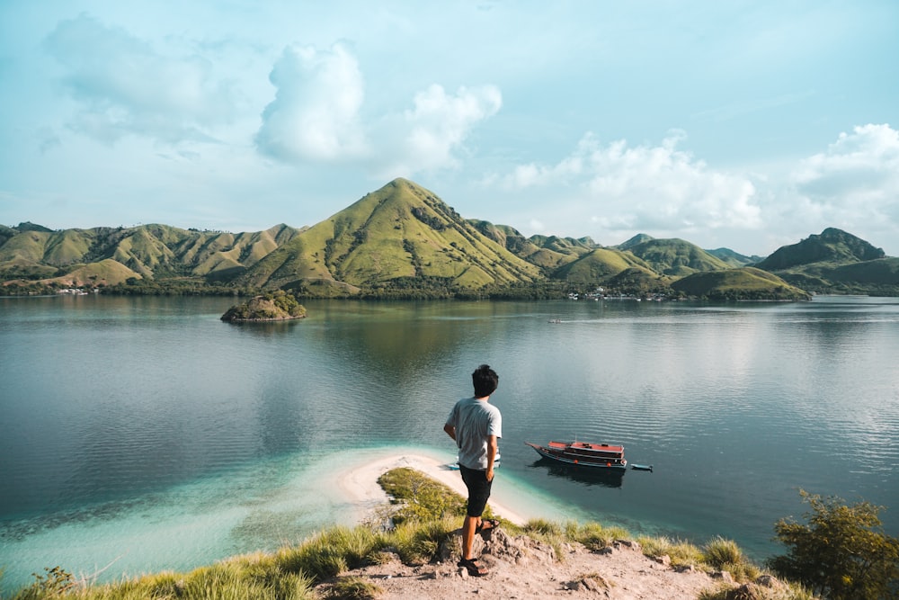 man standing beside lake