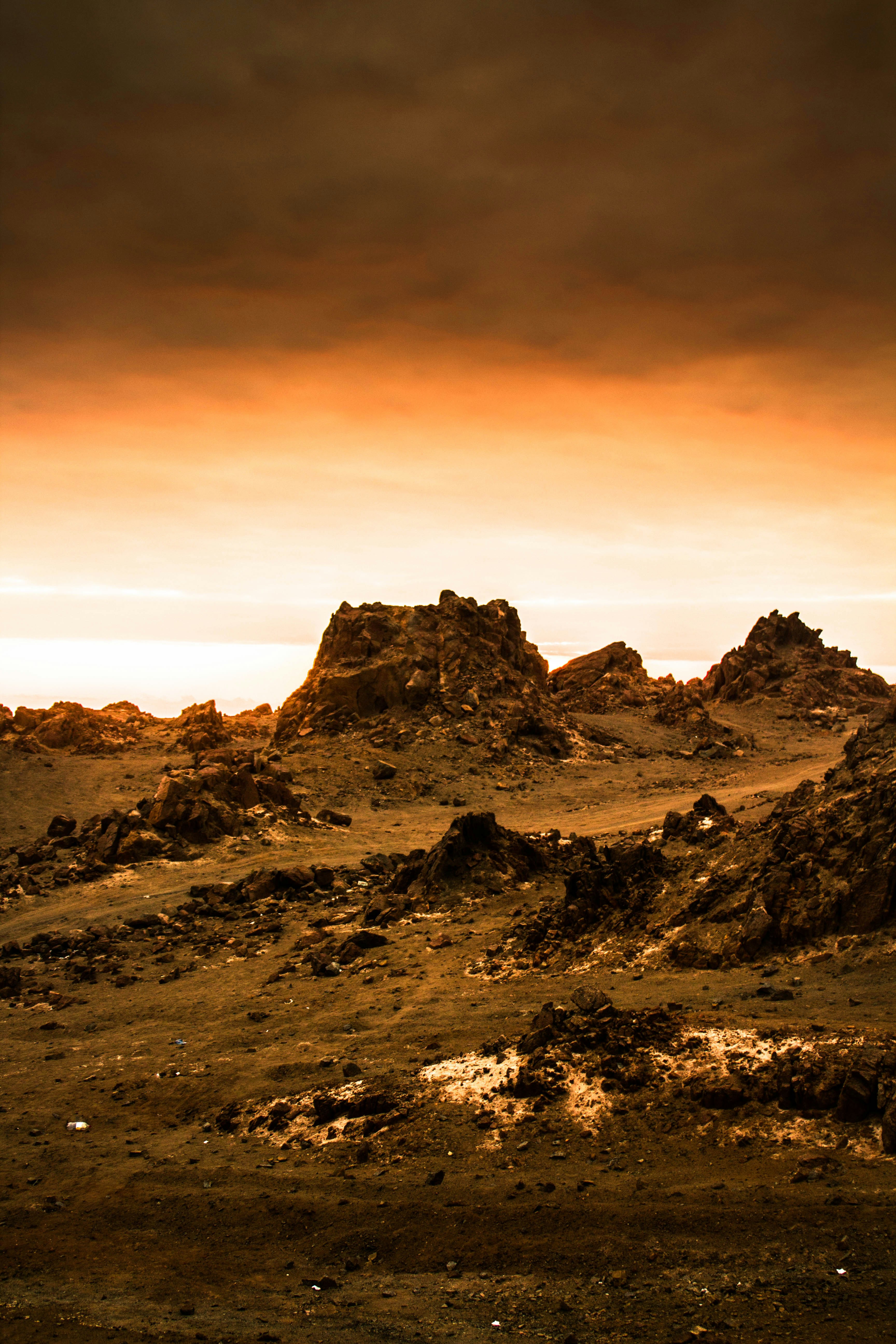 Red rocky Mars surface with atmospheric haze and distant craters under orange sky