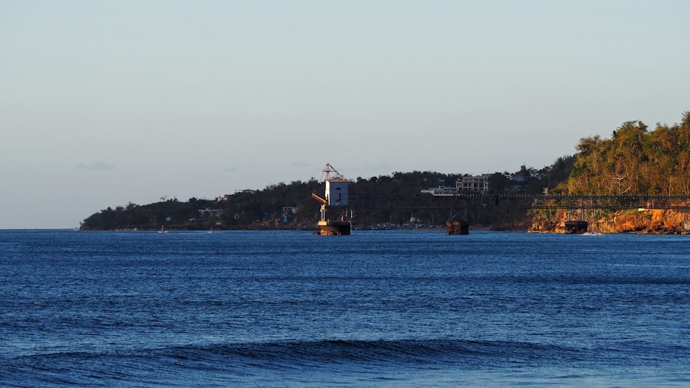 red and white sail boat in the middle of ocean