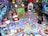 A vibrant pinball machine playfield featuring colorful graphics and electronic components, dominated by cartoonish monster figures and playful elements. The surface is densely packed with buttons, flashing lights, and ramps, creating an energetic and chaotic aesthetic.