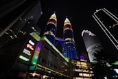 A group of tourists enjoying a guided tour in front of Malaysia’s iconic Petronas Towers.