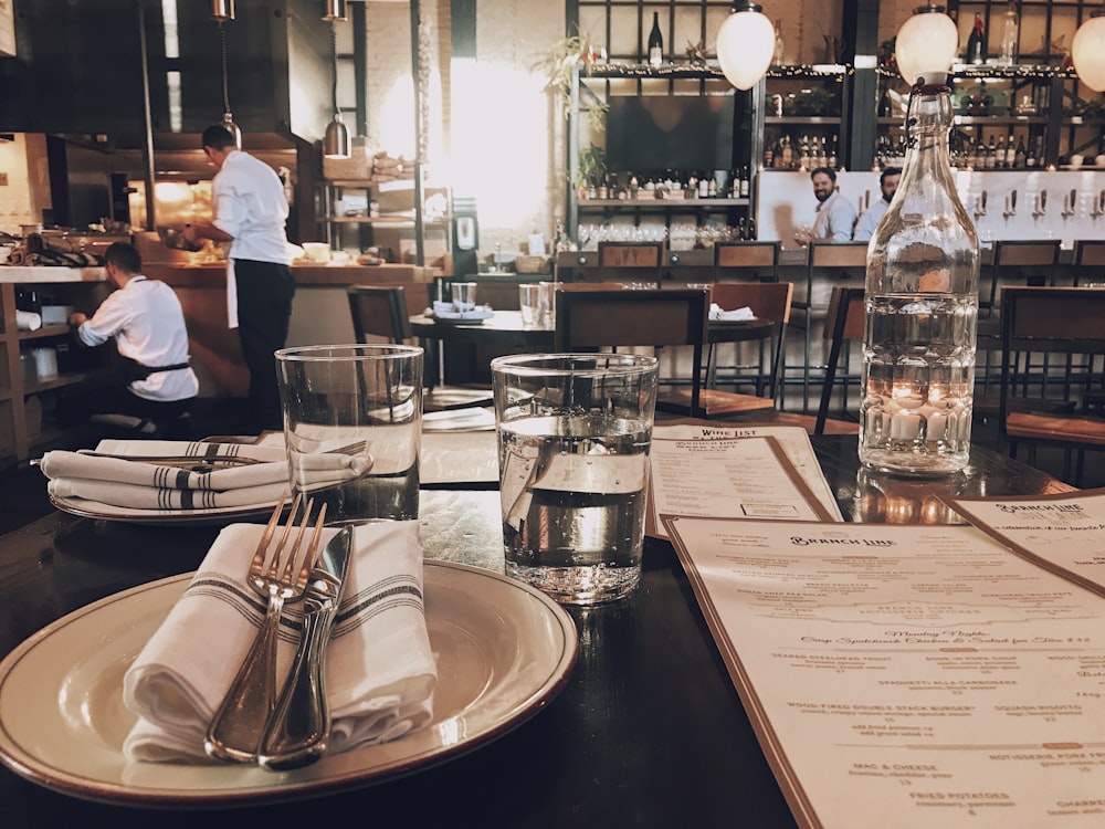 fork and knife on plate beside drinking glass