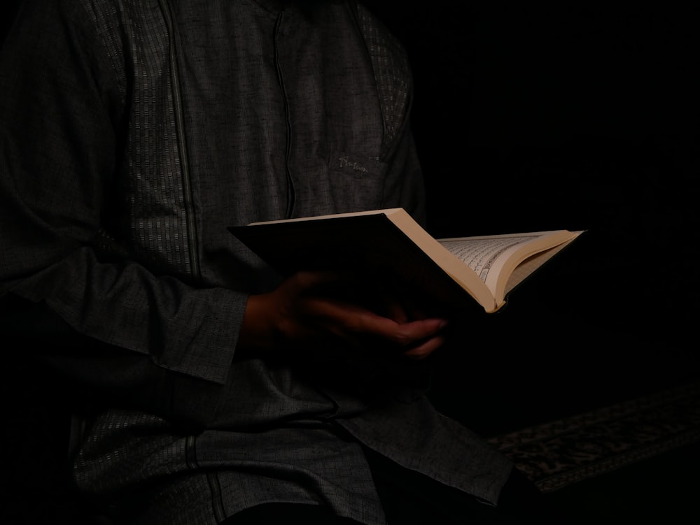 person sitting and holding opened book