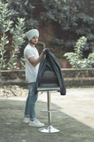 A man wearing a crisp white panjabi paired with casual jeans, walking through a city park.