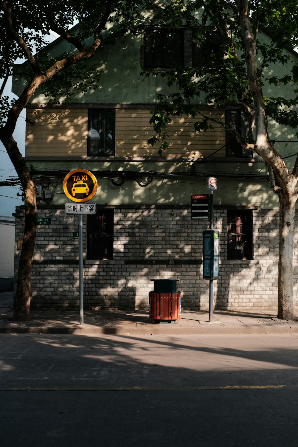 taxi signboard on pole beside building during day