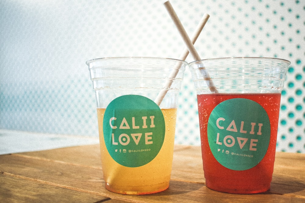 나무 표면에 두 개의 Calii Love 음료 채워진 컵