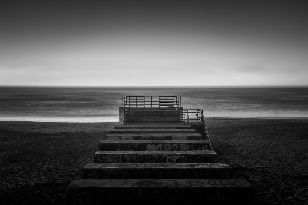 Photographie en niveaux de gris d’un escalier en béton près de la mer