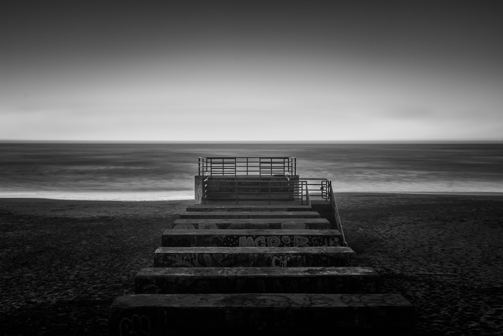 grayscale photography of concrete stair near sea