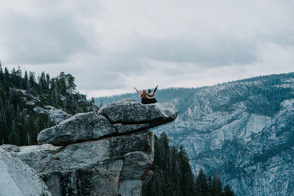 two people standing on rock