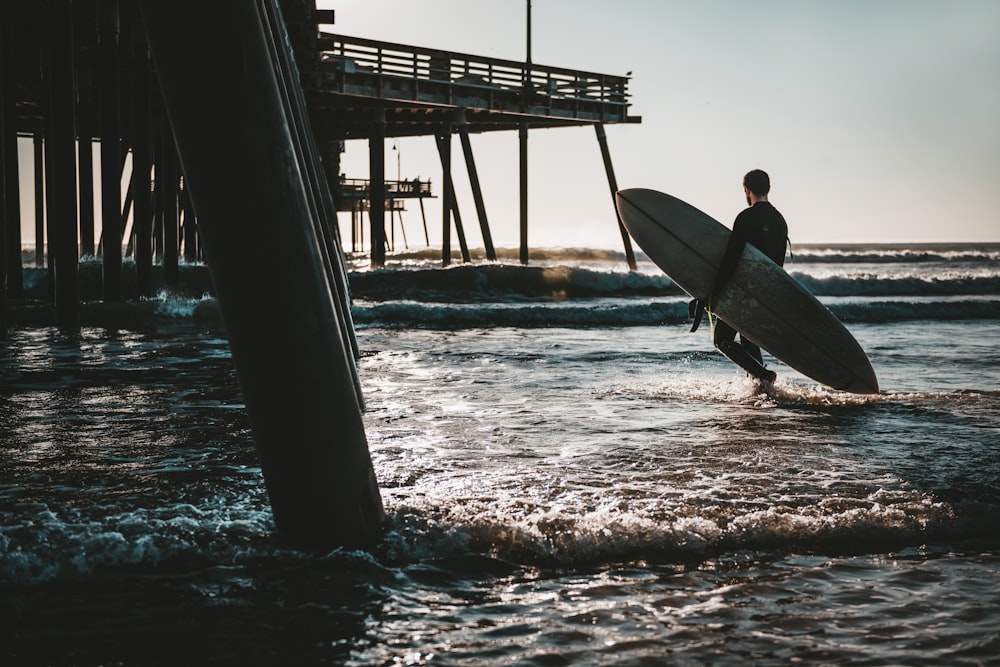 Hombre que lleva una tabla de surf