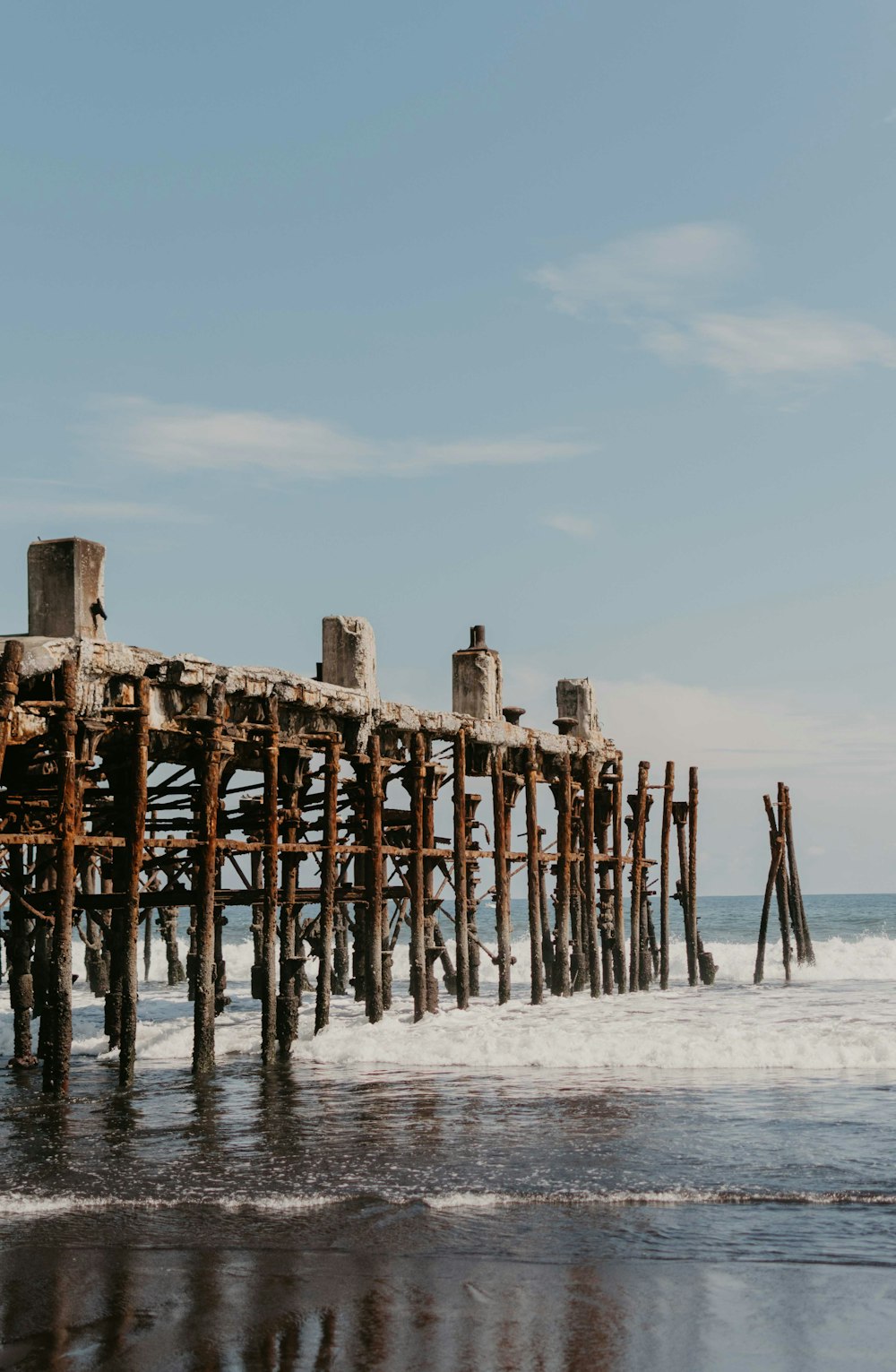 brown wooden dock viewing blue sea under blue and white sky during daytime