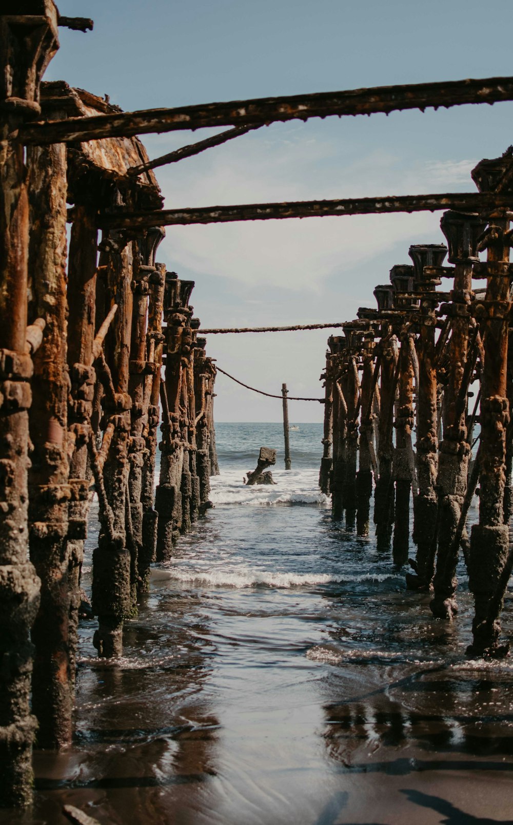 a man riding a surfboard under a wooden structure