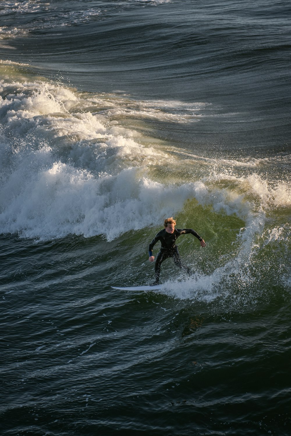 a man riding a wave on top of a surfboard