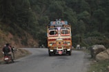 A truck navigating through a scenic highway in India.