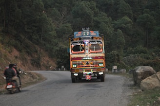 A vibrant mobile advertising truck with colorful banners driving through Chiang Mai streets.