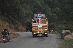 A truck navigating through a scenic highway in India.