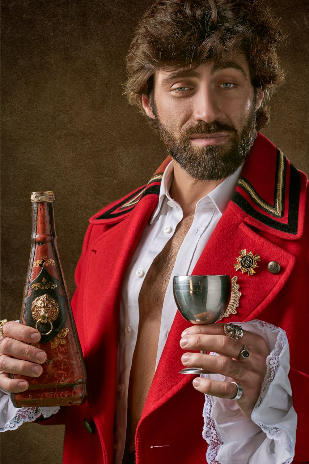 man wearing red and black coat standing and holding bottle and glass of wine