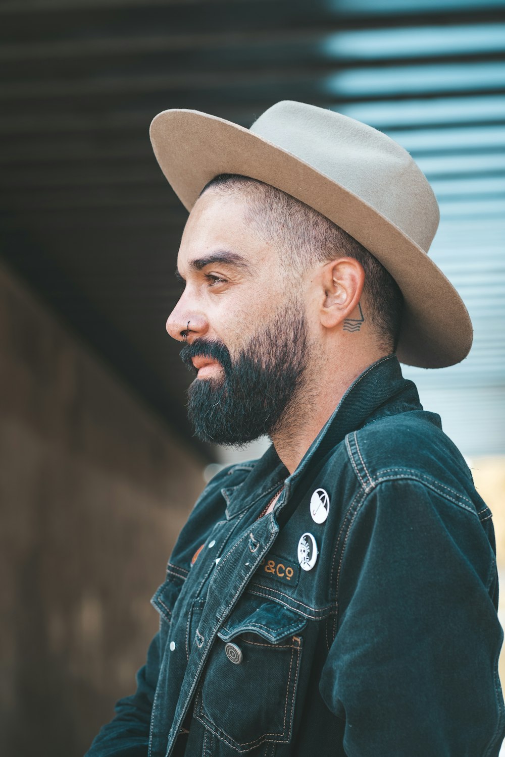 man wearing blue denim jacket and brown hat