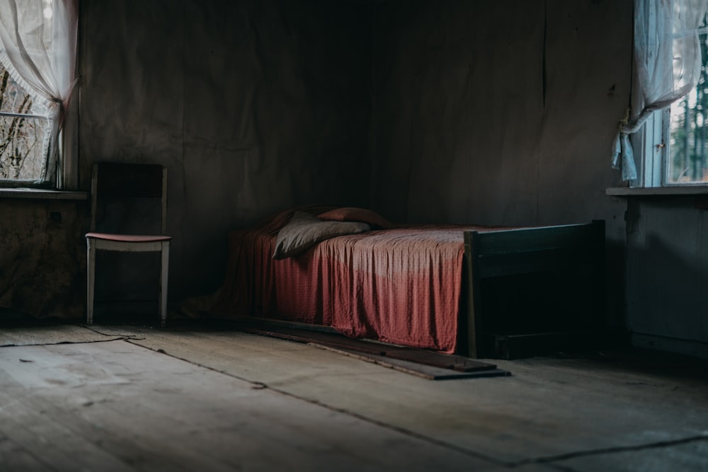Estrutura de cama de madeira marrom com lençol vermelho