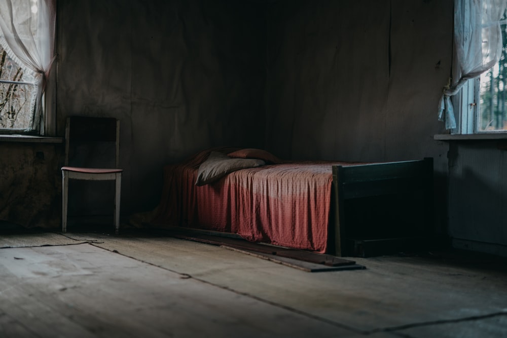 brown wooden bed frame with red bed sheet