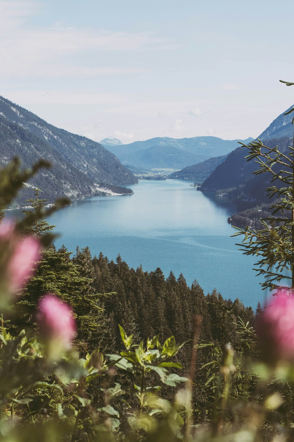 body of water between mountains under white sky