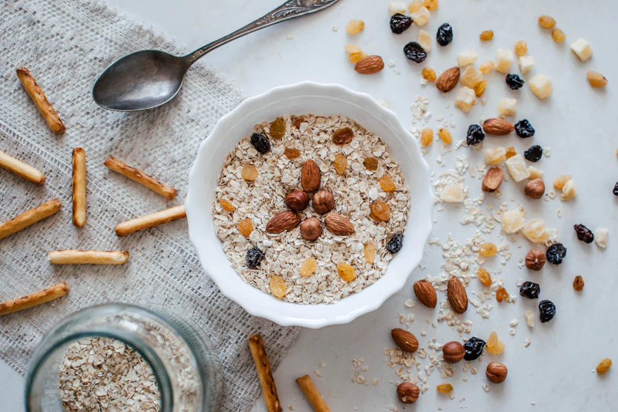 A fluted bowl of raw grains with a spoon on a pale cloth