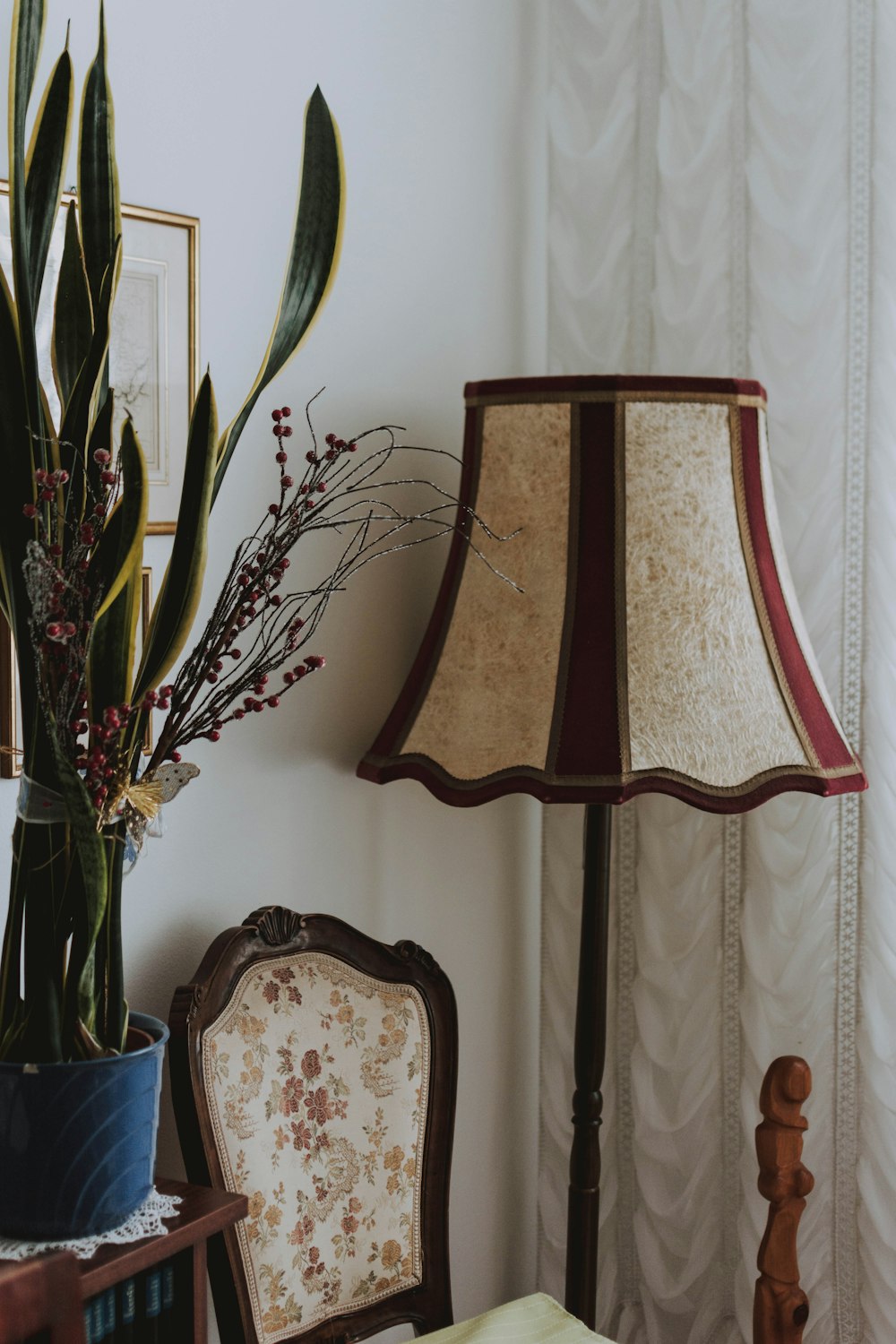 beige-maroon floor lamp by curtain panel