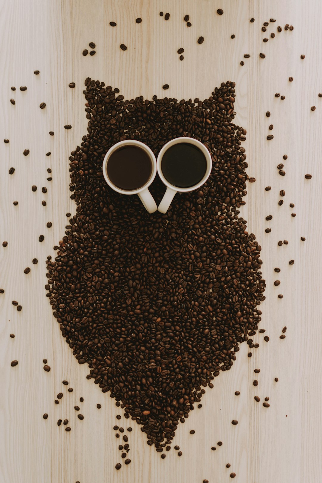 top view of ceramic mugs on top of coffee beans