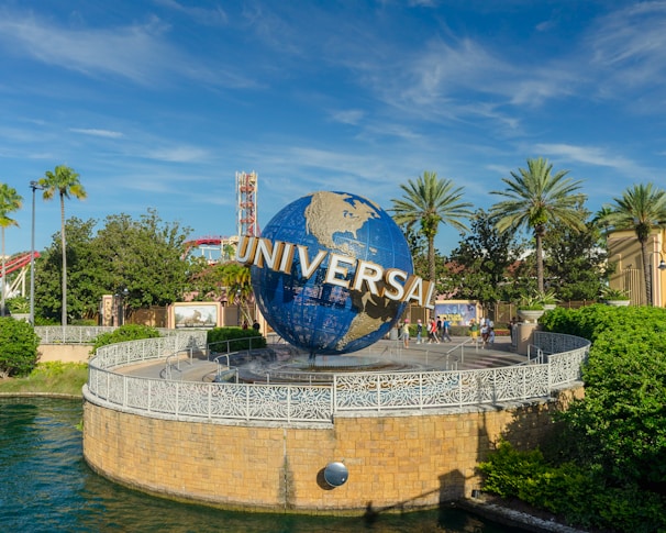 Sunset view of the iconic Universal Studios globe in Orlando with visitors around.