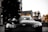 A sleek luxury car parked in an urban setting with modern architecture in the background.