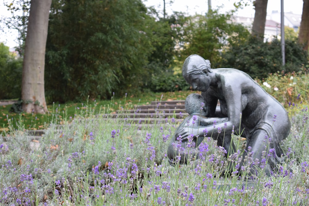 woman about to carry child statue in garden