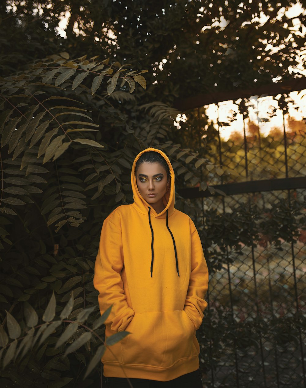 woman in hoodie by tree