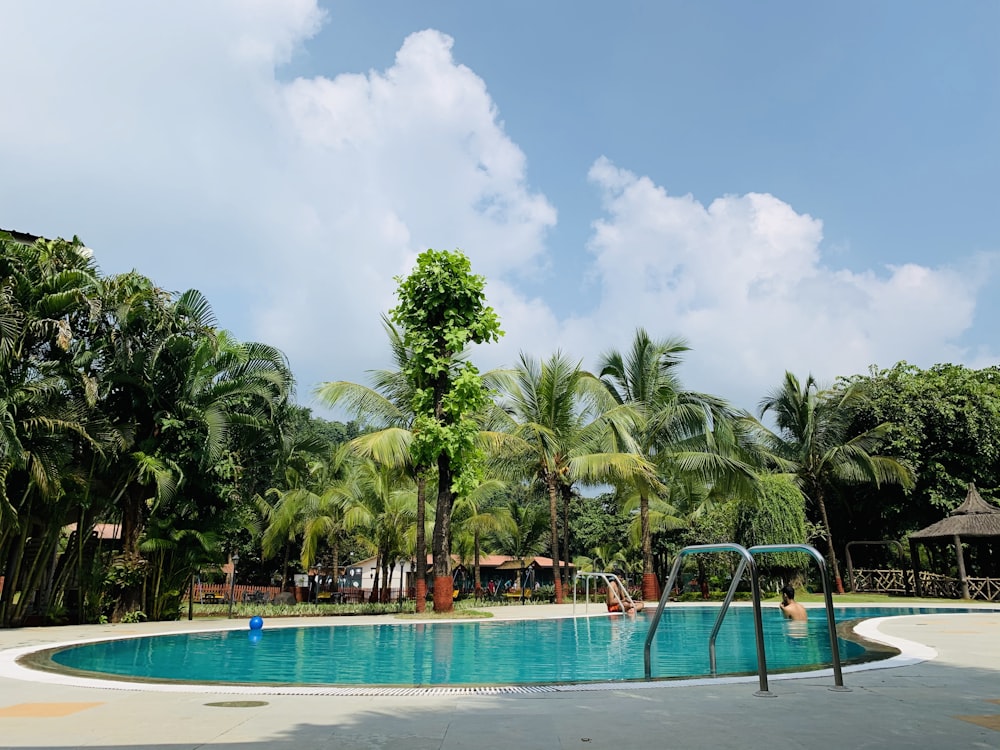 swimming pool near trees and gazebos