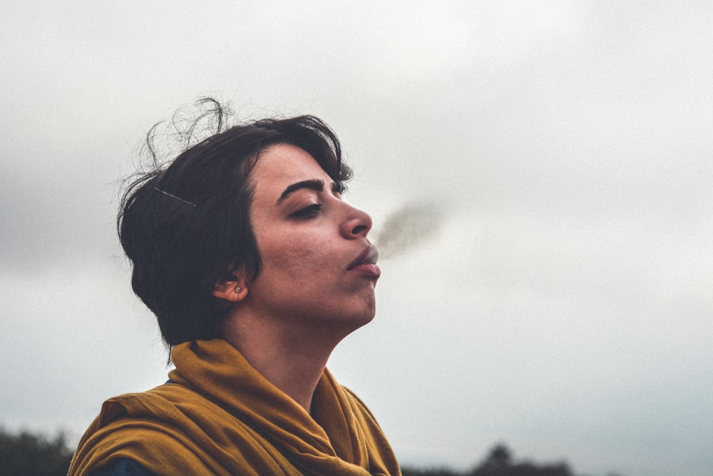 man wearing yellow top smoking