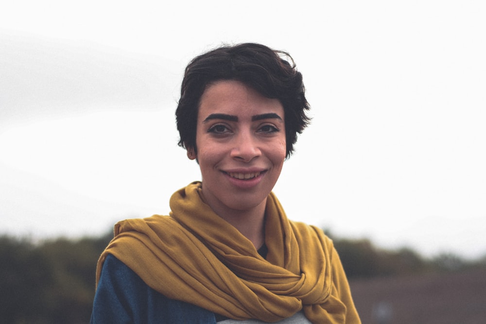 smiling woman in blue top and brown scarf