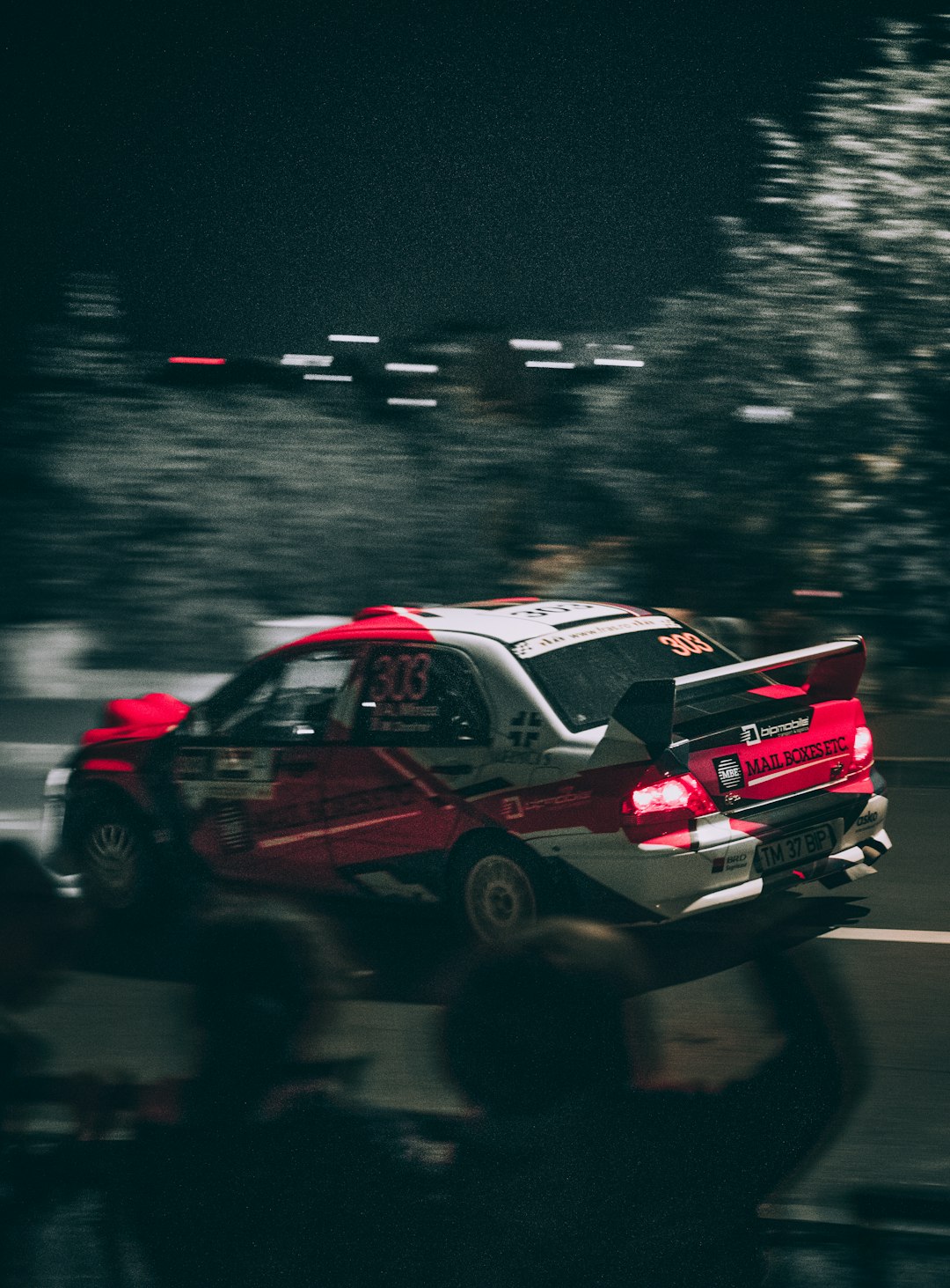 red and white racing car on road during night time