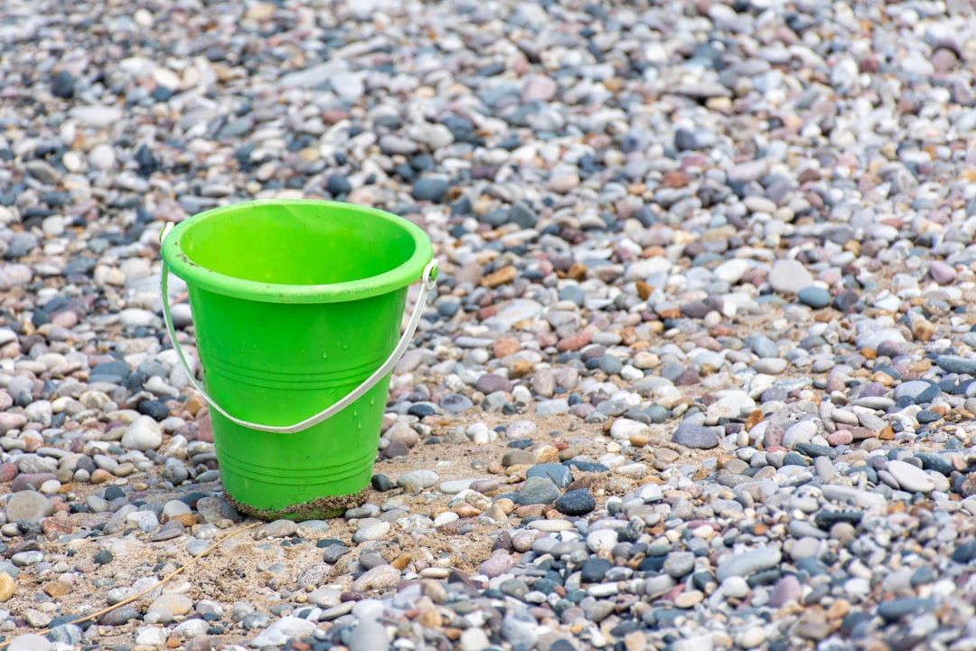  green plastic bucket on stones bucket