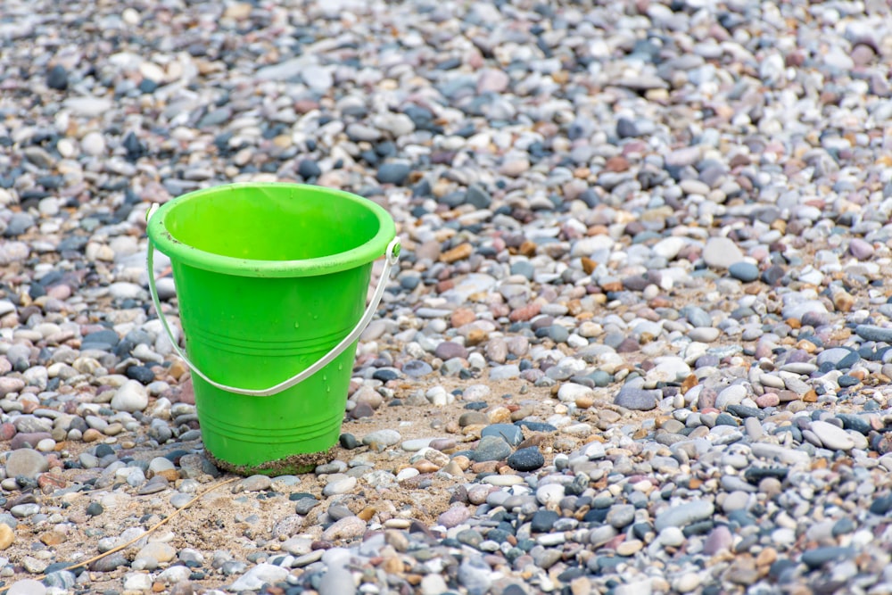 green plastic bucket on stones