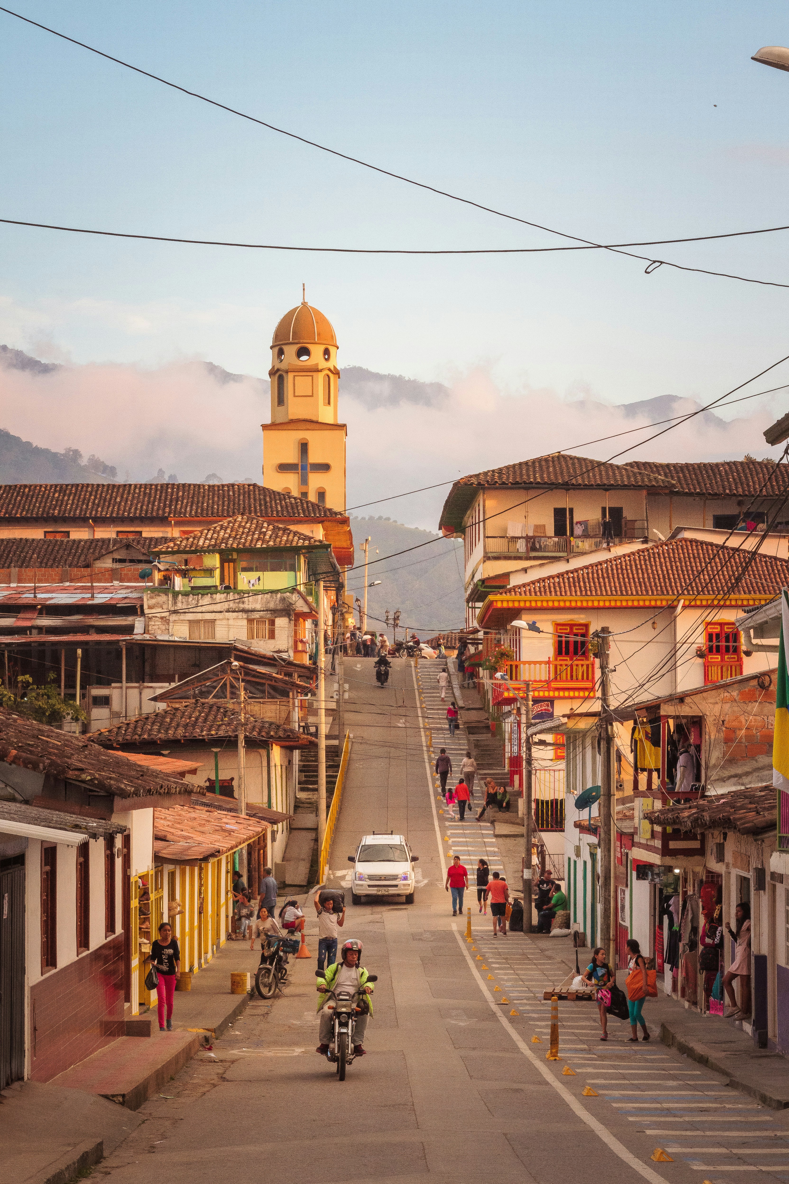 people and vehile on road between establishments