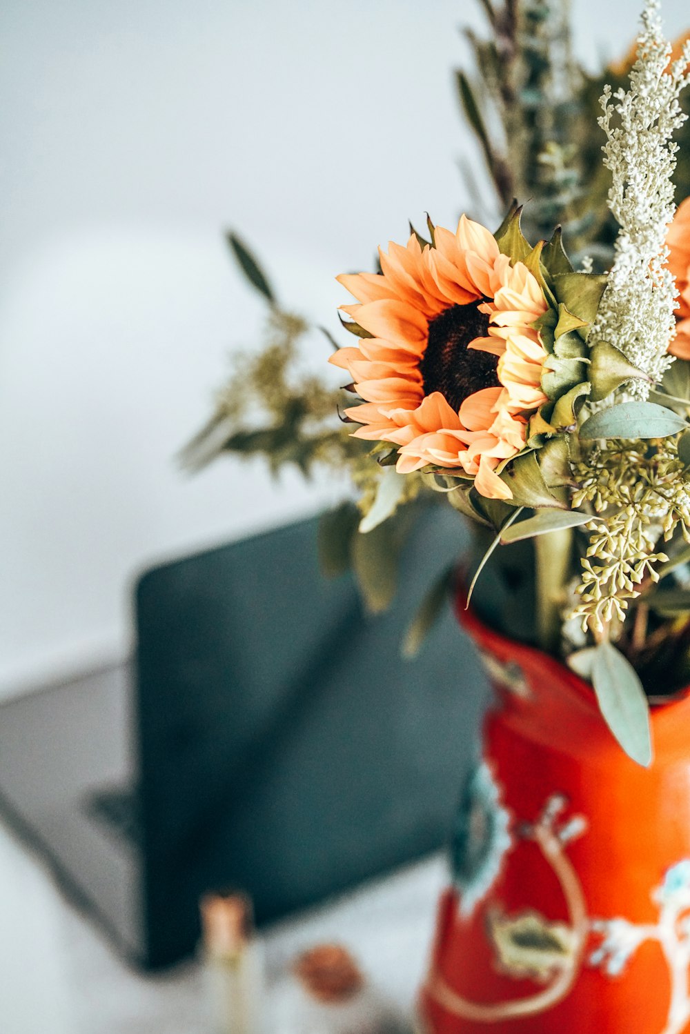 flowers in vase near laptop