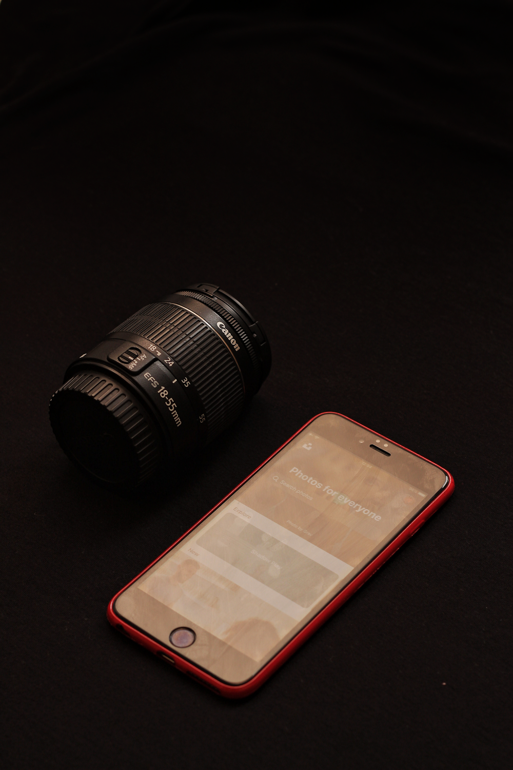 red smartphone beside zoom lens