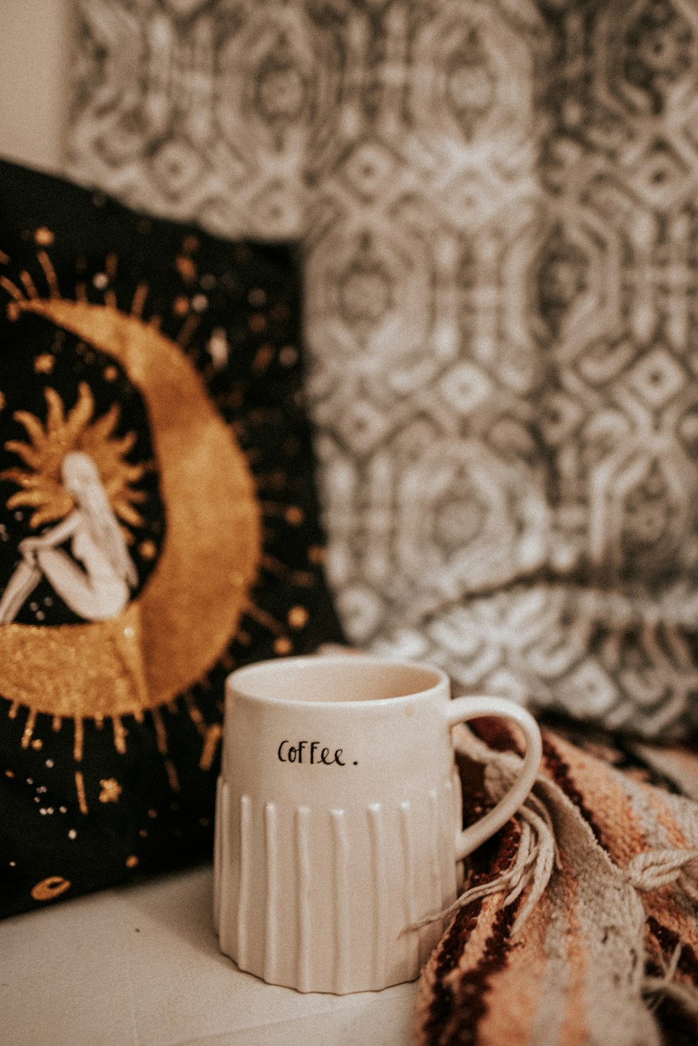 white mug beside gray textile
